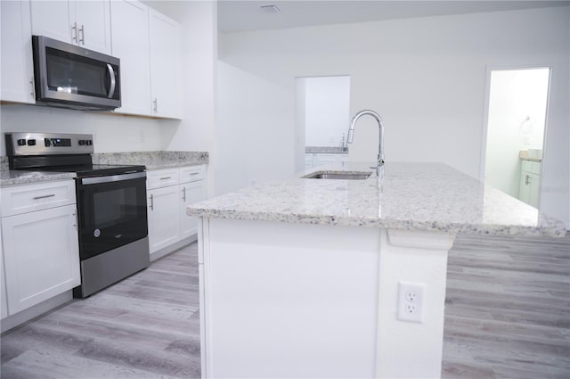 kitchen with a center island with sink, sink, white cabinetry, and stainless steel appliances