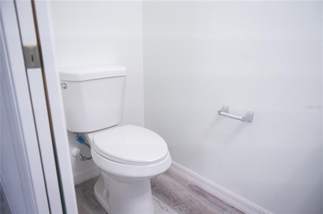 bathroom with hardwood / wood-style floors and toilet