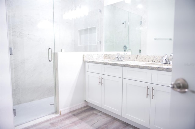 bathroom featuring a shower with door, vanity, and wood-type flooring