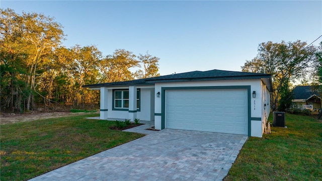 single story home featuring a garage and a front lawn