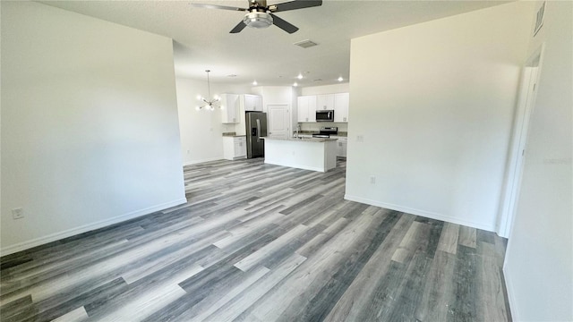 unfurnished living room with a textured ceiling, ceiling fan with notable chandelier, and hardwood / wood-style flooring