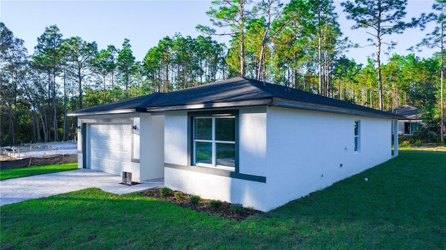 view of side of property with a garage and a lawn