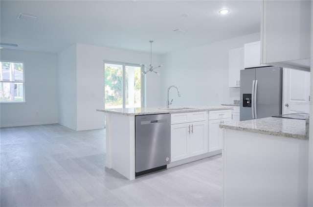 kitchen featuring sink, an island with sink, pendant lighting, white cabinets, and appliances with stainless steel finishes