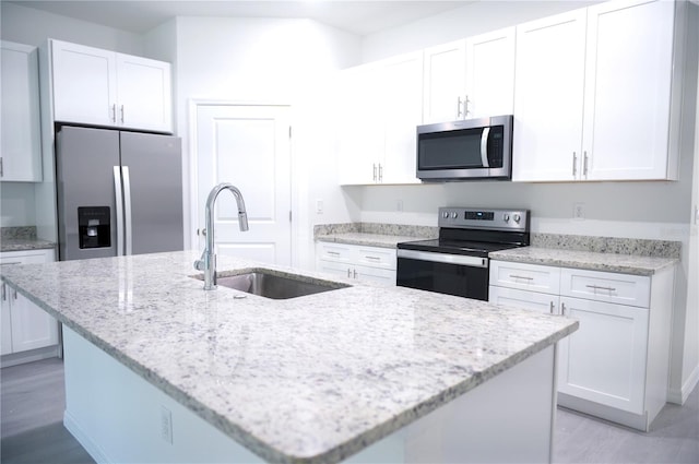 kitchen with sink, white cabinetry, stainless steel appliances, and an island with sink