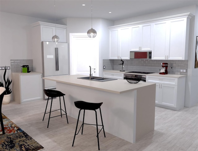 kitchen featuring white fridge, white cabinetry, sink, and hanging light fixtures