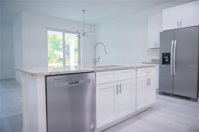 kitchen featuring white cabinetry, sink, pendant lighting, a center island with sink, and appliances with stainless steel finishes