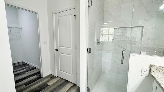 bathroom with wood-type flooring, vanity, and an enclosed shower