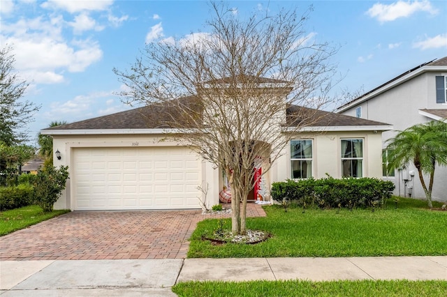 view of front of property featuring a front yard and a garage