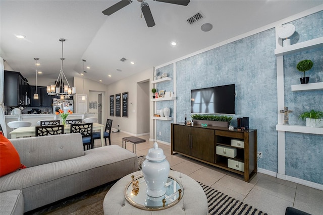 living room with tile patterned floors, ceiling fan with notable chandelier, and vaulted ceiling