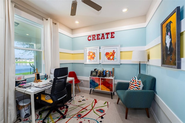 office area with a water view and ceiling fan