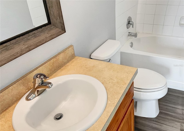 full bathroom with toilet, tiled shower / bath combo, vanity, and hardwood / wood-style flooring