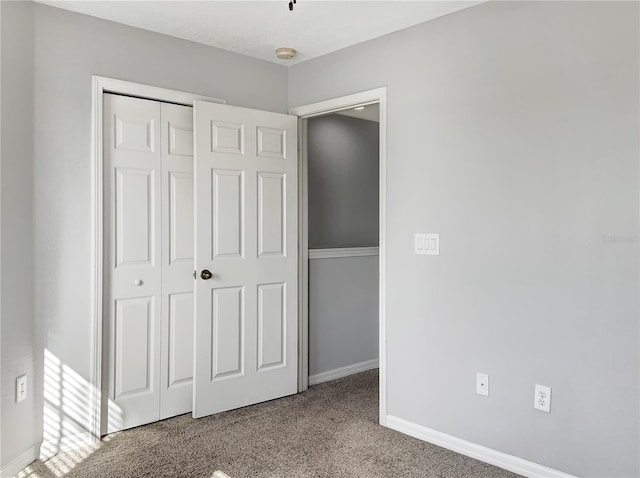 unfurnished bedroom featuring light colored carpet and a closet