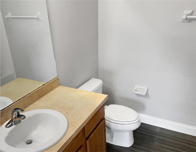 bathroom with hardwood / wood-style flooring, vanity, and toilet