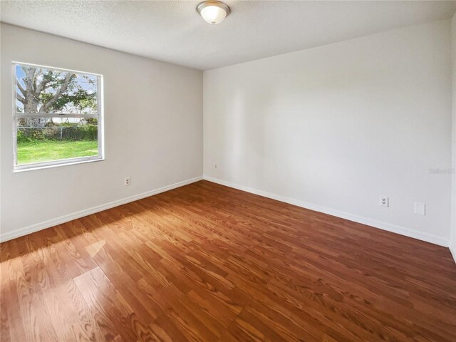 spare room with wood-type flooring and a textured ceiling