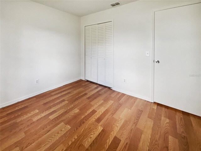 unfurnished bedroom featuring light hardwood / wood-style floors and a closet