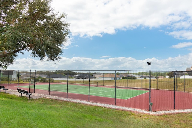 view of tennis court with a lawn