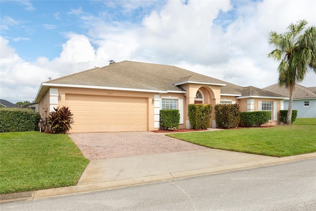 view of front of property with a garage and a front lawn