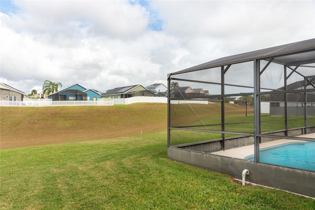 view of yard featuring glass enclosure and a fenced in pool