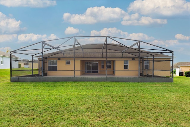 back of property featuring glass enclosure, a yard, and a patio