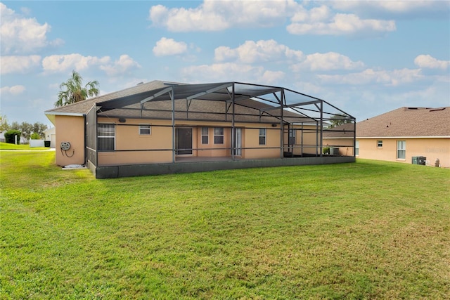 rear view of house featuring glass enclosure and a yard