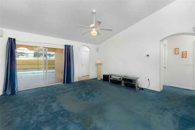 unfurnished living room with ceiling fan, dark colored carpet, a textured ceiling, and vaulted ceiling