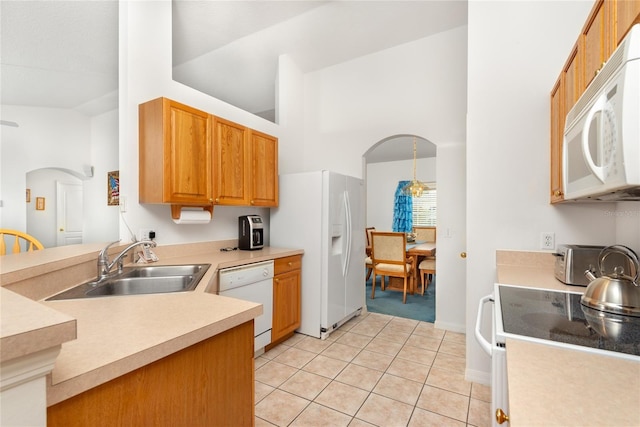 kitchen with light tile patterned floors, sink, high vaulted ceiling, pendant lighting, and white appliances