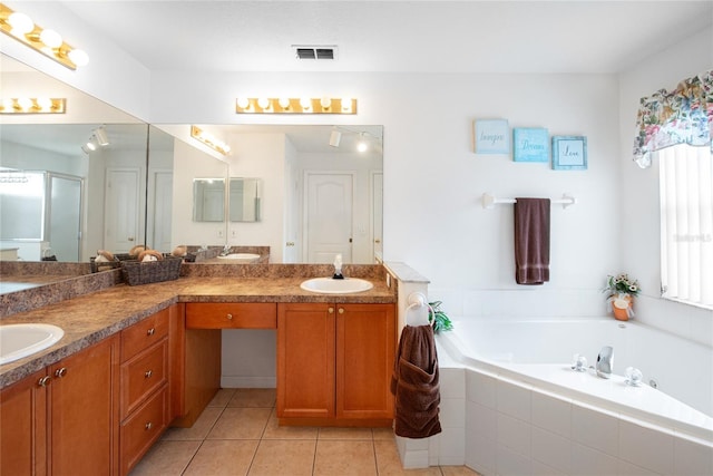 bathroom featuring tiled bath, vanity, and tile patterned floors