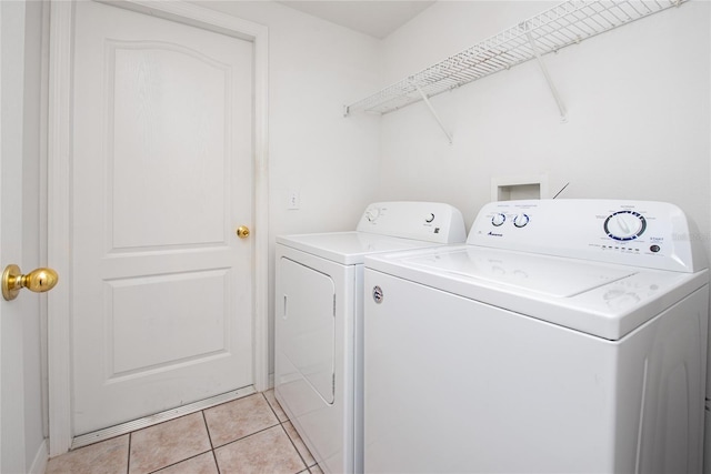 laundry room with independent washer and dryer and light tile patterned floors