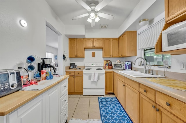 kitchen featuring white appliances, sink, light tile patterned floors, and ceiling fan