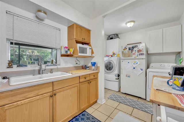 washroom featuring light tile patterned floors, sink, and washing machine and clothes dryer