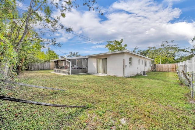 rear view of property with a sunroom and a yard