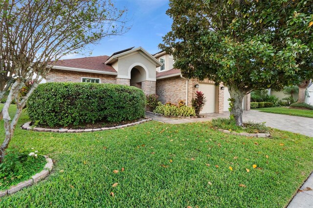 2626 Raccoon Run Ln, Orlando, FL 32837 - view of front of property featuring stucco siding, a front lawn, driveway, and a garage