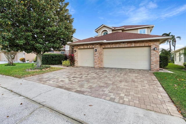 2626 Raccoon Run Ln, Orlando, FL 32837 - view of front of property featuring decorative driveway, an attached garage, a front lawn, and brick siding