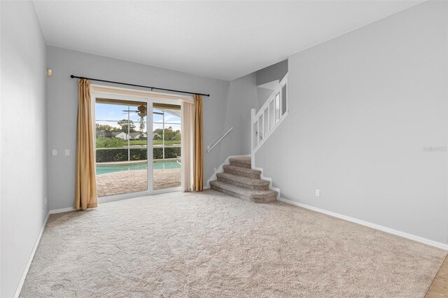 2626 Raccoon Run Ln, Orlando, FL 32837 - spare room featuring baseboards, stairway, and carpet