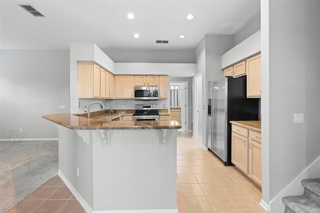 2626 Raccoon Run Ln, Orlando, FL 32837 - kitchen with appliances with stainless steel finishes, light tile patterned floors, a peninsula, light brown cabinets, and recessed lighting