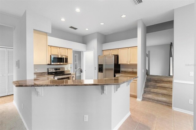 2626 Raccoon Run Ln, Orlando, FL 32837 - kitchen with appliances with stainless steel finishes, a peninsula, a breakfast bar area, light brown cabinets, and recessed lighting