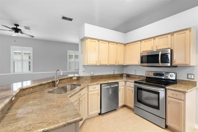 2626 Raccoon Run Ln, Orlando, FL 32837 - kitchen featuring stainless steel appliances, a sink, light brown cabinetry, a ceiling fan, and light stone countertops