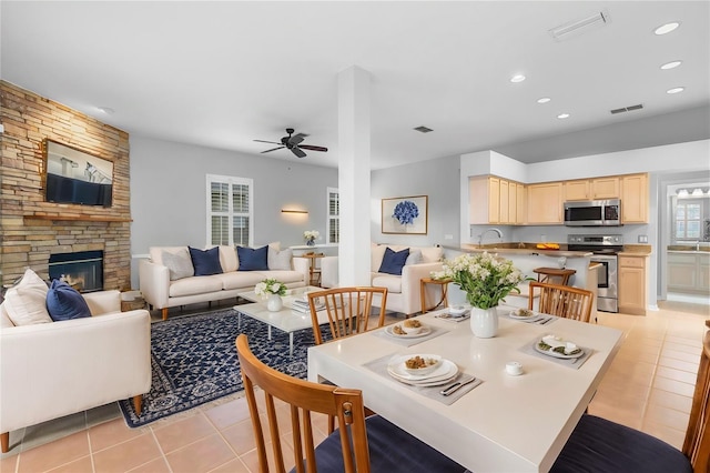 2626 Raccoon Run Ln, Orlando, FL 32837 - dining room featuring light tile patterned flooring, a ceiling fan, a stone fireplace, and recessed lighting