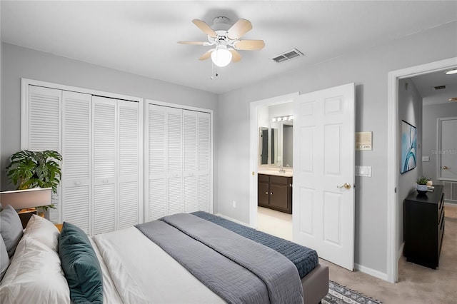 2626 Raccoon Run Ln, Orlando, FL 32837 - bedroom featuring two closets, baseboards, light carpet, a sink, and connected bathroom