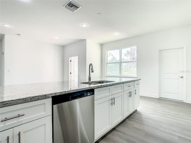 kitchen featuring white cabinets, light stone counters, stainless steel dishwasher, light hardwood / wood-style floors, and sink