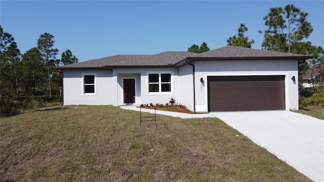 view of front of home featuring concrete driveway, a front lawn, an attached garage, and stucco siding