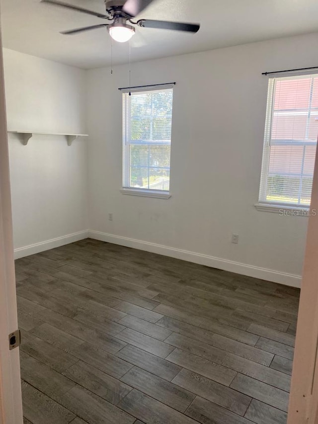 unfurnished room with ceiling fan, a healthy amount of sunlight, and dark hardwood / wood-style flooring