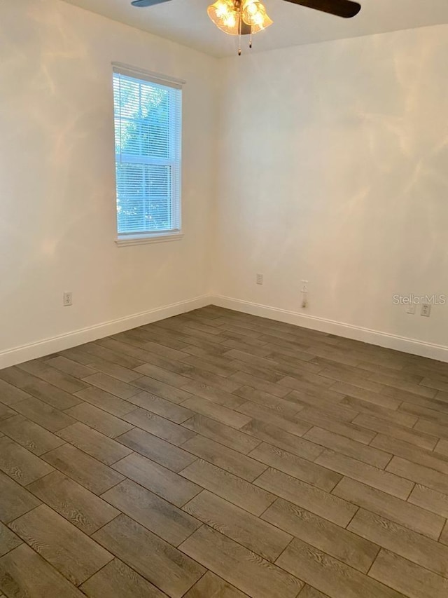 spare room with dark hardwood / wood-style floors and ceiling fan