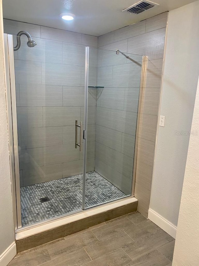 bathroom featuring a shower with door