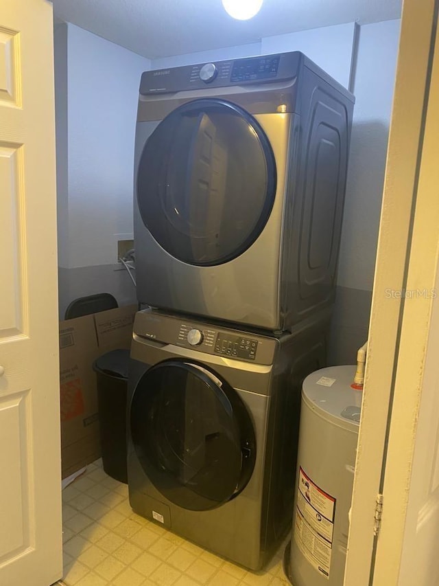 laundry room with electric water heater and stacked washer and clothes dryer