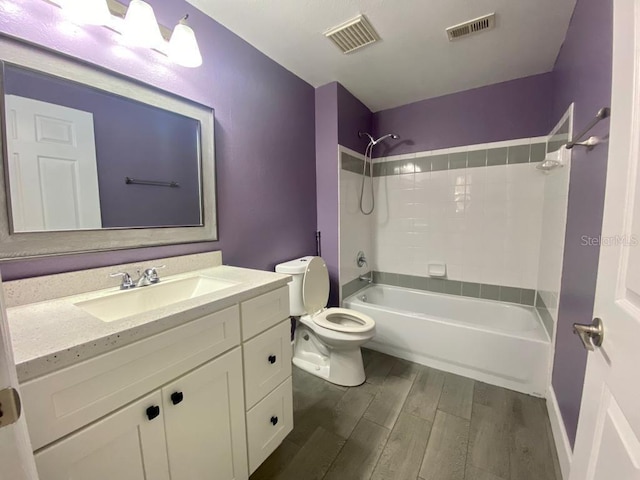 full bathroom featuring hardwood / wood-style floors, vanity, toilet, and tub / shower combination