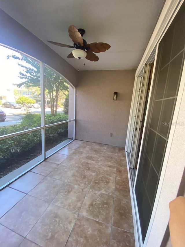 unfurnished sunroom featuring ceiling fan