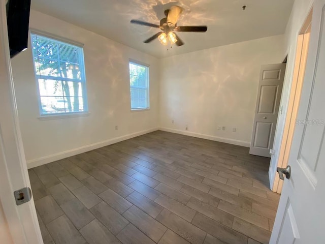 spare room with ceiling fan and dark wood-type flooring