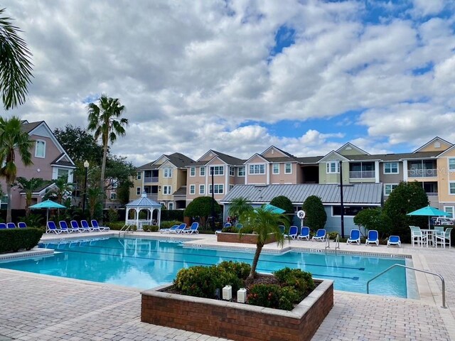 3468 Soho St Unit 107, Orlando, FL 32835 - community pool featuring a gazebo, a patio area, and a residential view