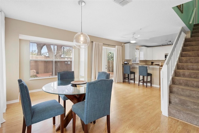 dining room with light wood-type flooring, ceiling fan, and plenty of natural light